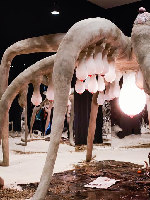 Eine Frau steht in der Kunsthalle Mannheim in der Ausstellung "1,5 Grad. Verflechtungen von Leben, Kosmos, Technik" vor dem Kunstwerk "Moother" von Laure Prouvost.  