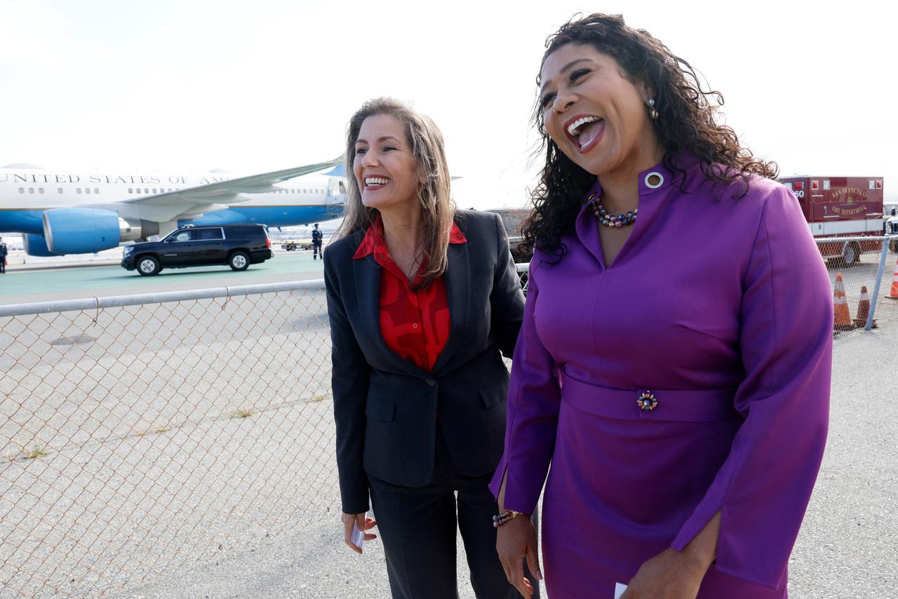 Oaklands Bürgermeisterin Libby Schaaf mit San Franciscos Bürgermeisterin London Breed auf einem Flugfeld. Beide Frauen lächeln freundlich.