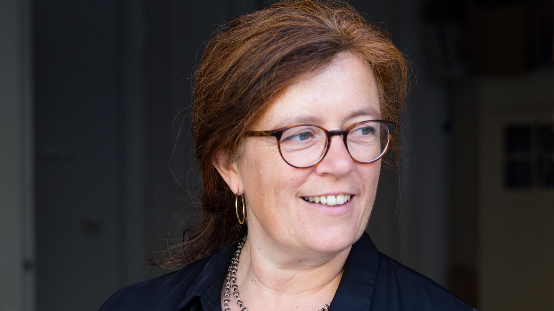 Porträt der Rechtsanwältin Christina Clemm. Sie hat lange rote Haare und trägt eine Brille. Porträt der Rechtsanwältin Christina Clemm. Sie hat lange rote Haare und trägt eine Brille.