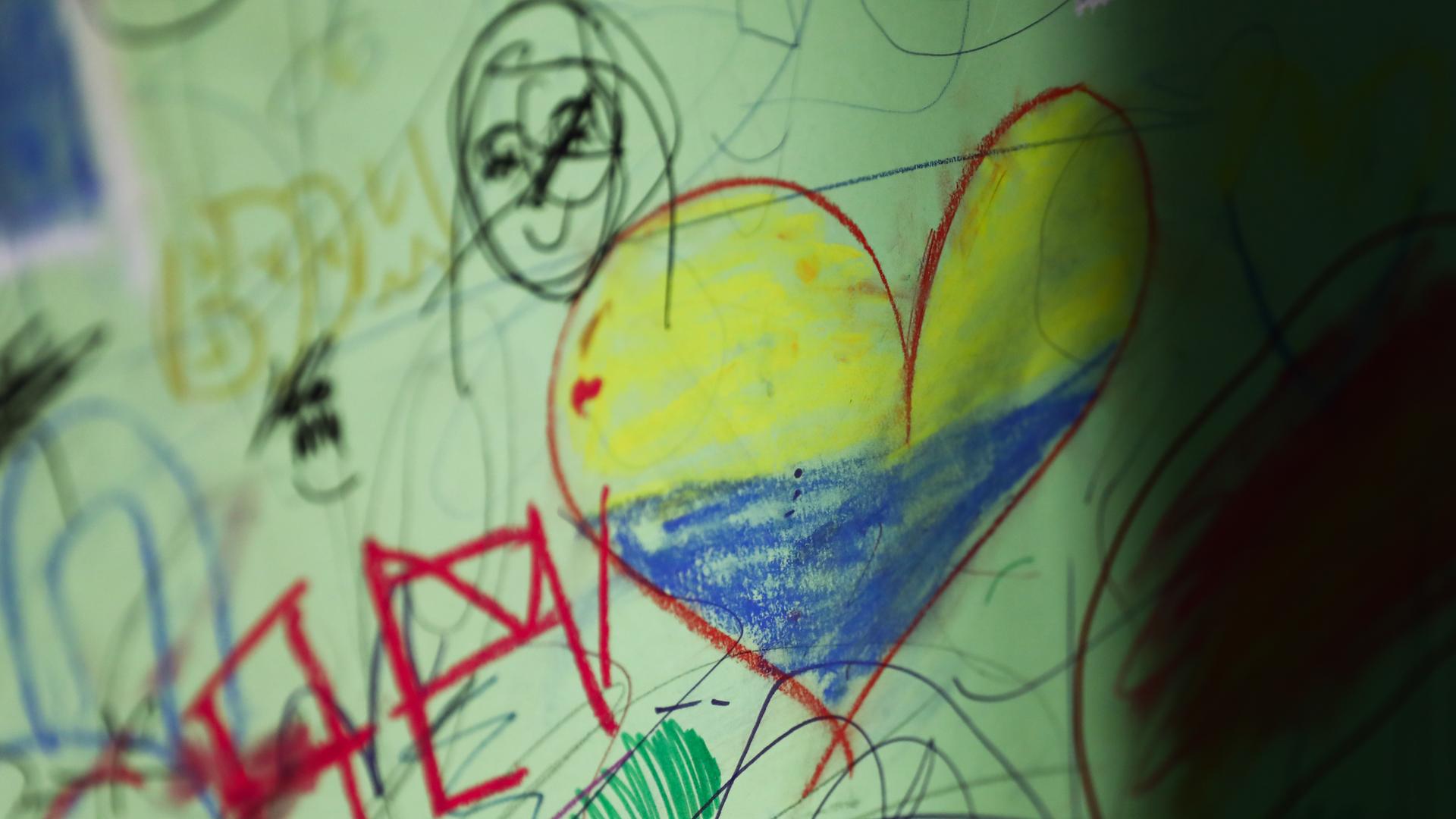 Eine Zeichnung, die ein aus der Ukraine geflohenens Kind in Polen angefertigt hat, zeigt unter anderem ein Herz in den ukrainischen Landesfarben.
