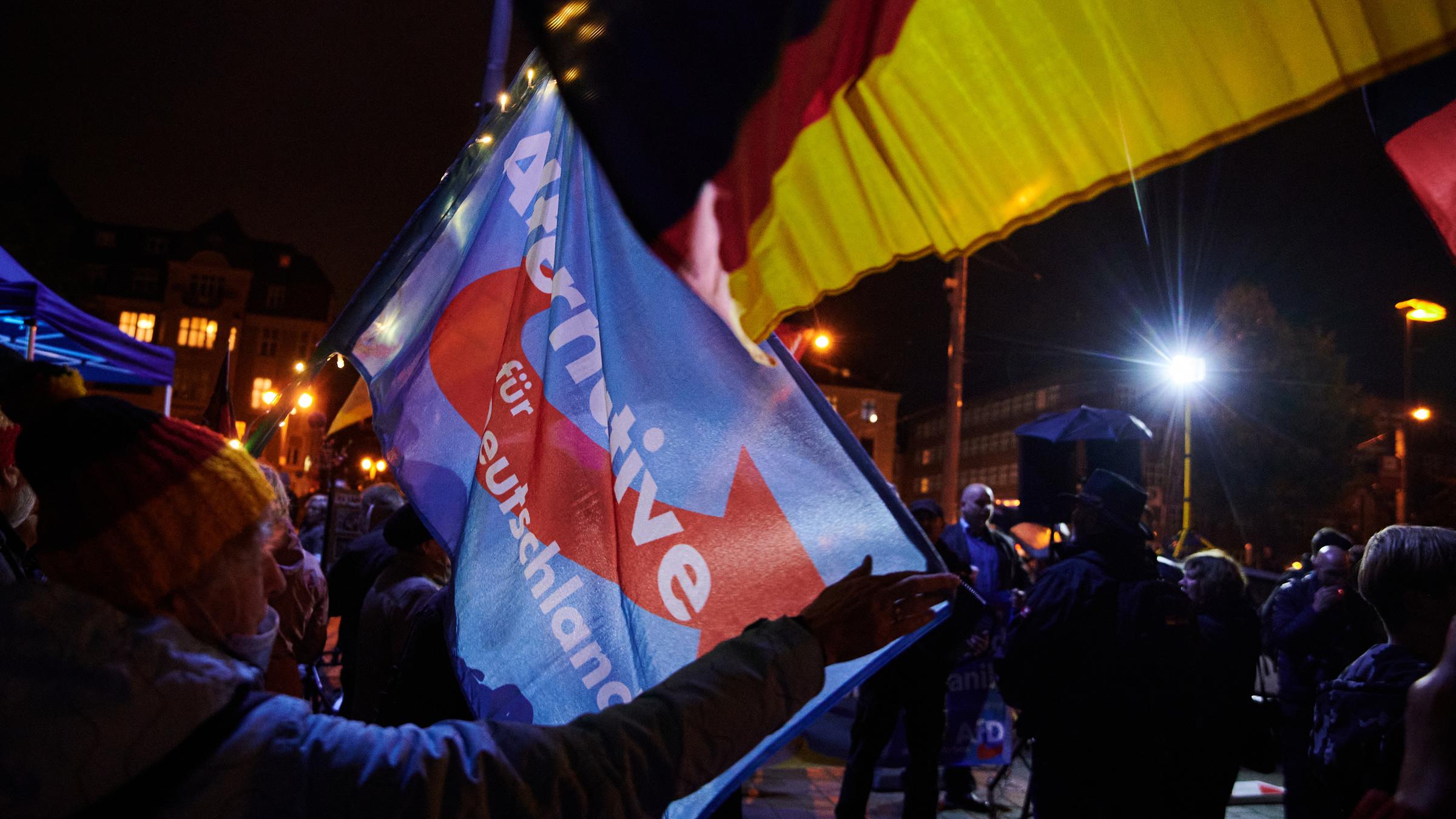 Eine Teilnehmerin schwingt eine AfD-Flagge während einer Kundgebung der islam- und ausländerfeindlichen Pegida-Bewegung vor der Cottbuser Stadthalle. Eine Teilnehmerin schwingt eine AfD-Flagge während einer Kundgebung der islam- und ausländerfeindlichen Pegida-Bewegung vor der Cottbuser Stadthalle.
