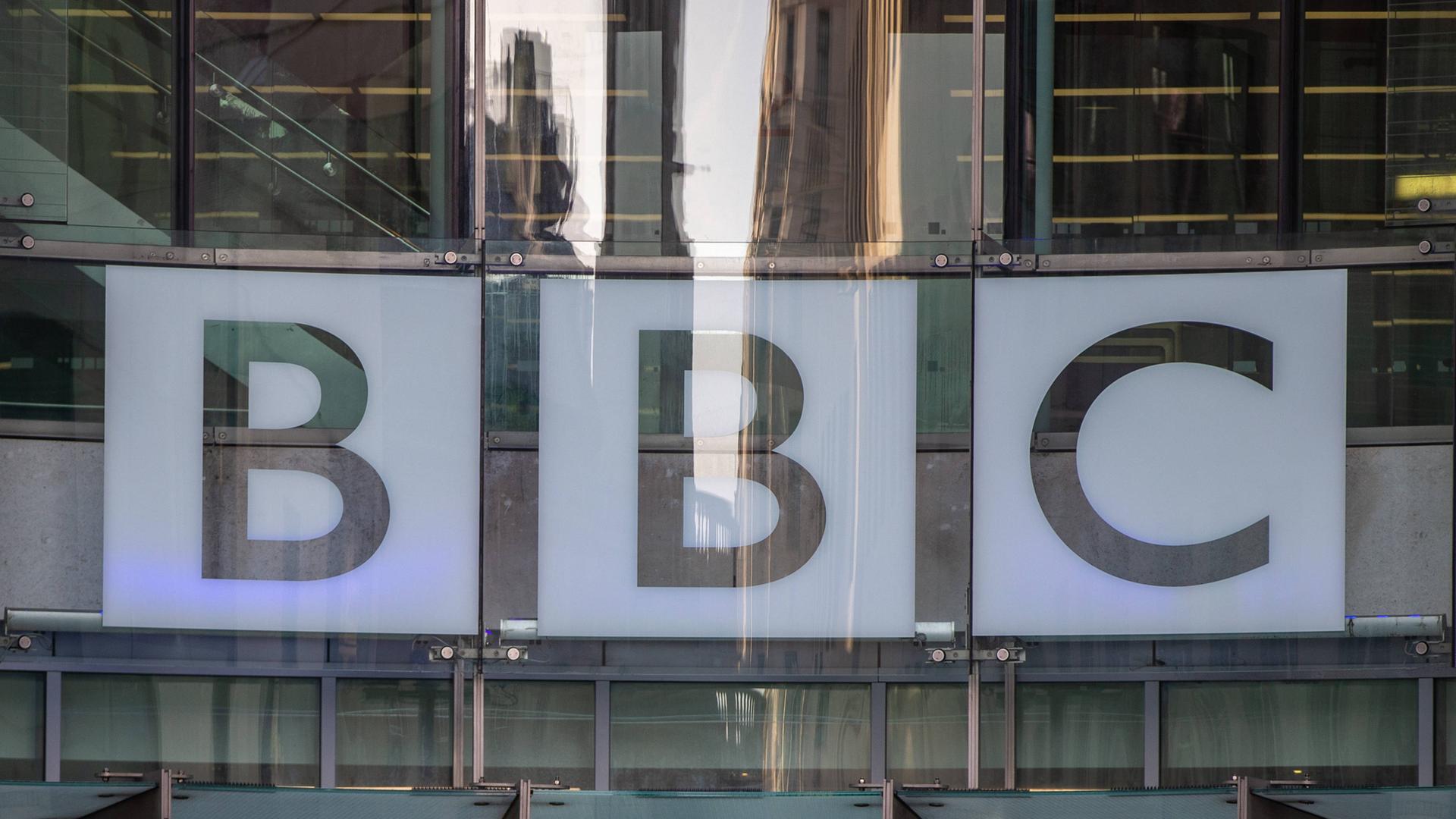 Das BBC-Logo hinter Glasscheiben an der Zentrale des Senders in London Das BBC-Logo hinter Glasscheiben an der Zentrale des Senders in London