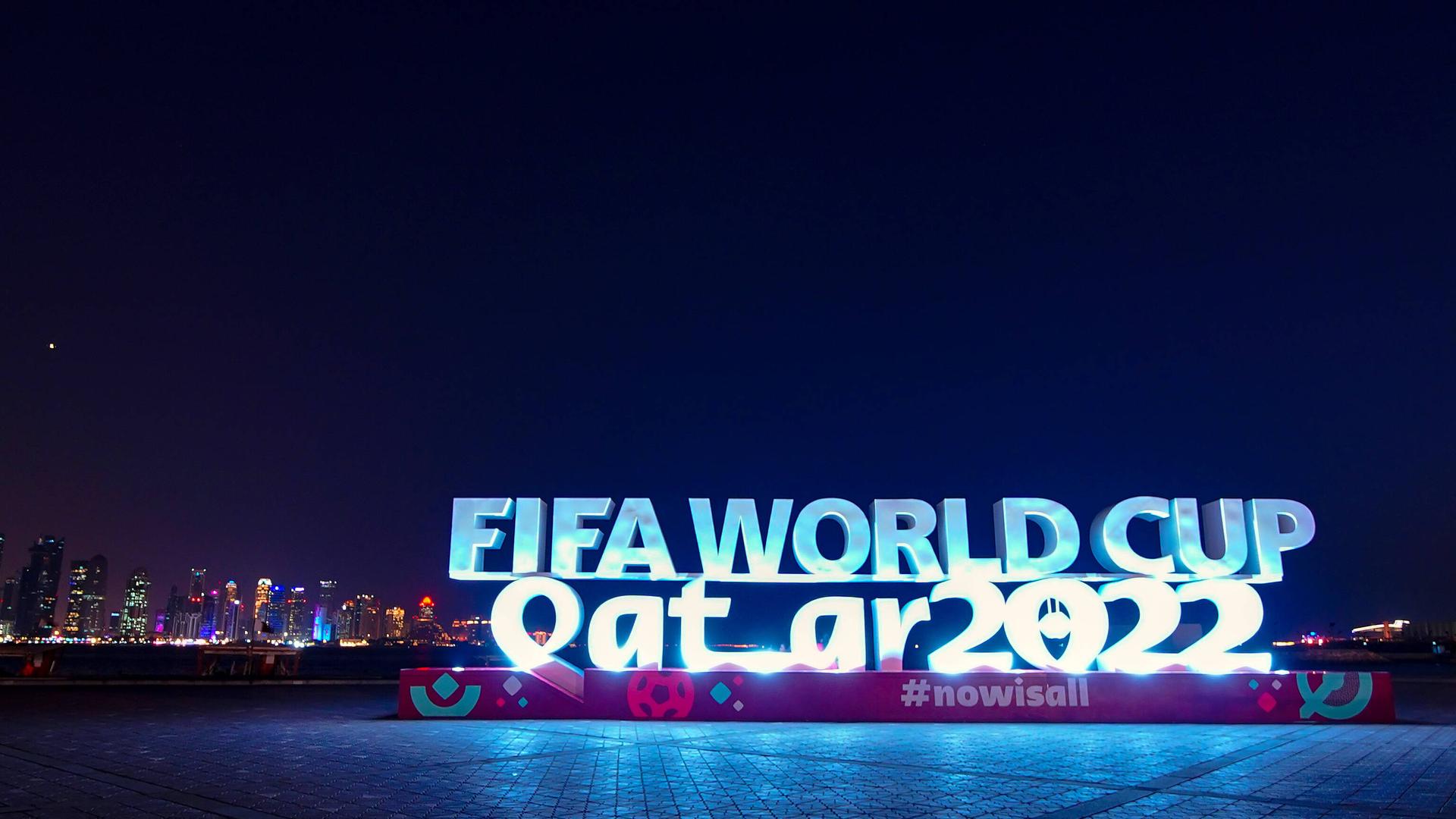 FIFA World Cup steht in beleuchteten Lettern vor der Skyline von Doha FIFA World Cup steht in beleuchteten Lettern vor der Skyline von Doha